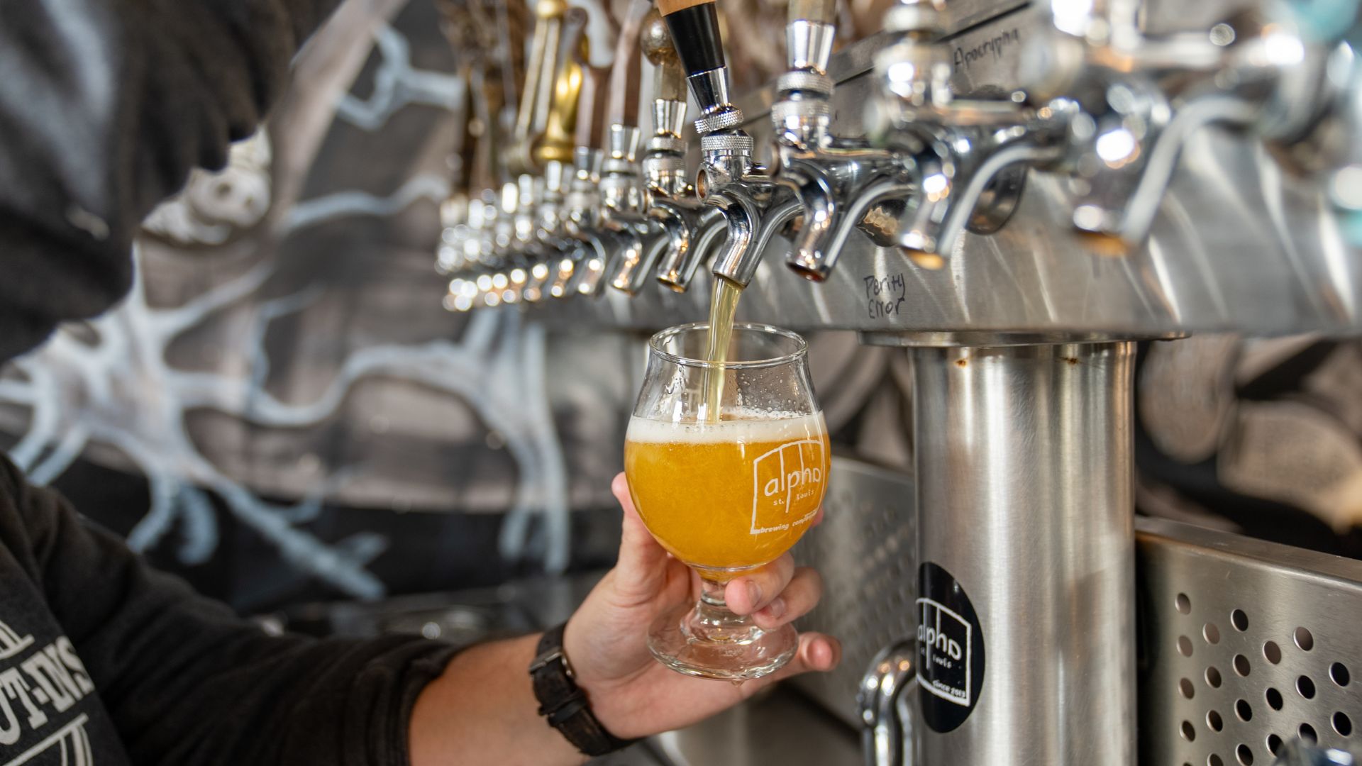 A sour beer pours from a tap at Alpha Brewing Co.