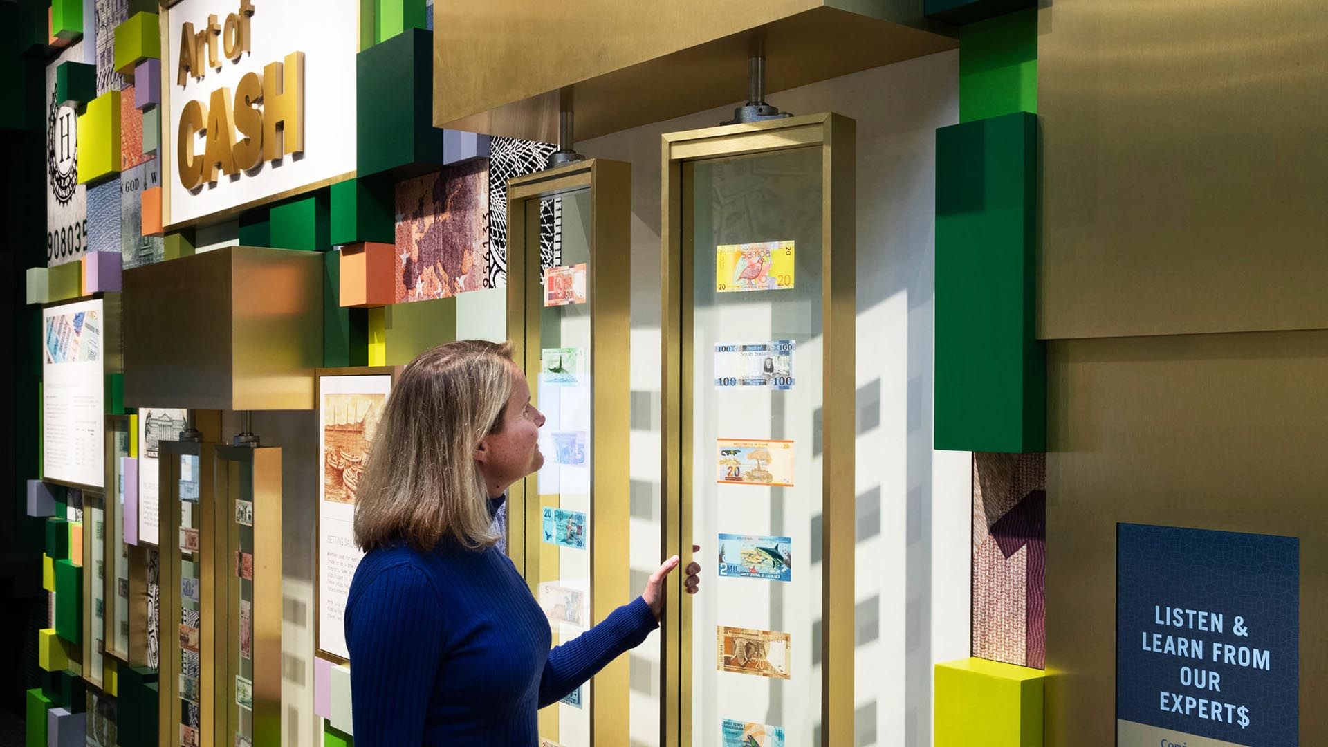 A woman examines artful money from around the world at the Economy Museum at the Federal Reserve Bank in St. Louis.