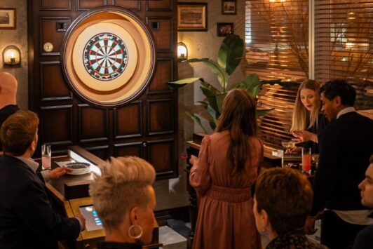 A crowd of people play at a new social darts bar in Clayton.