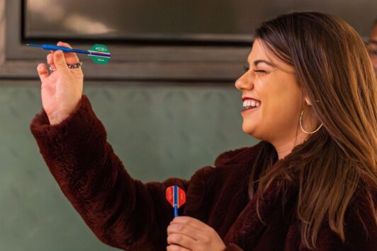 A woman throws a dart at Flight Club as a rainy day activity in St Louis.