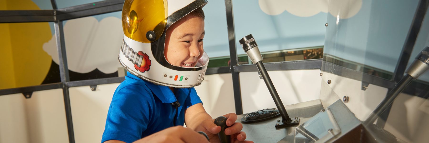 A young boy pretends to be an astronaut at the Saint Louis Science Center.