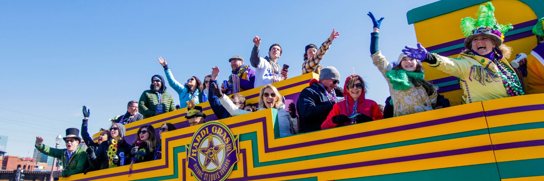 People throw beads from a float during Mardi Gras in Soulard.